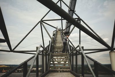 Low angle view of boy standing bridge staircase