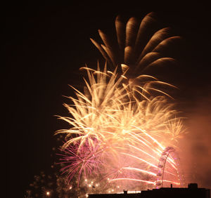 Low angle view of firework display against sky at night