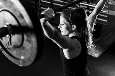 Cross training. female athlete lifting heavy barbells