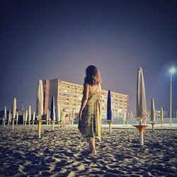 Rear view of woman standing against clear sky