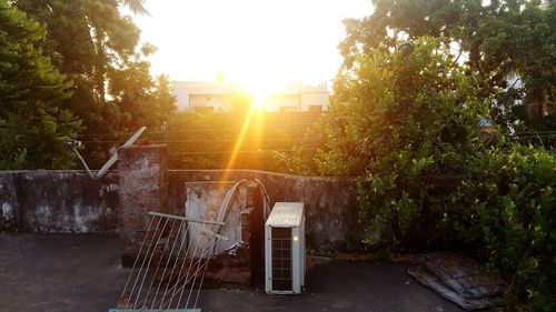 Built structure against trees at sunset