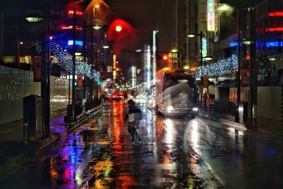 Illuminated cars on wet road at night