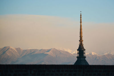 Tower of building against cloudy sky