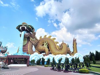 Statue against temple against sky