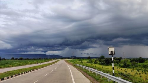 Empty road against cloudy sky