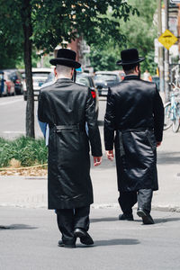 Rear view of people walking on footpath