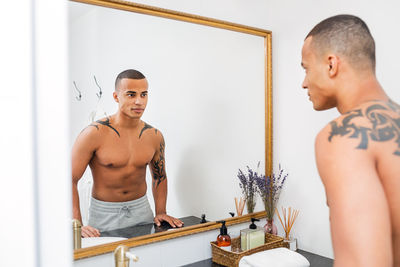 Portrait of young man standing at home