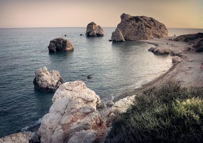 Rocks on sea shore against sky