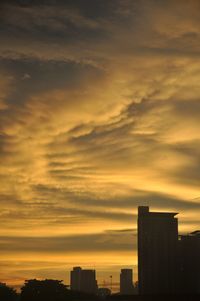 Silhouette buildings against sky during sunset