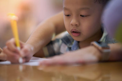 Cute boy writing on paper