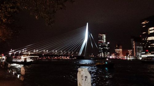 Illuminated bridge over river at night