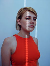 Portrait of beautiful young woman against gray background