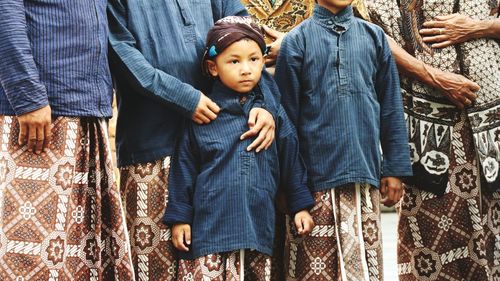 Family wearing traditional clothing while standing outdoors