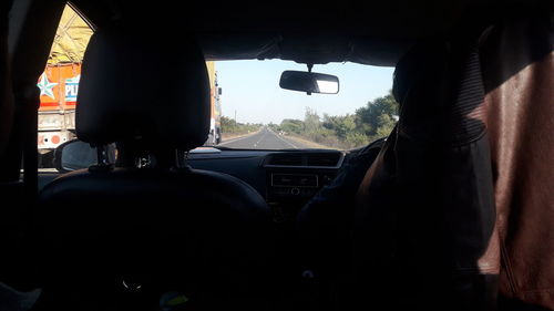 Rear view of man seen through car windshield