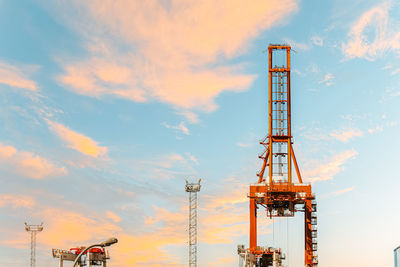 Low angle view of crane against sky during sunset