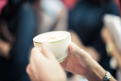 Cropped hands holding cup of cappuccino