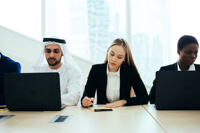 Business people discussing over laptop in office