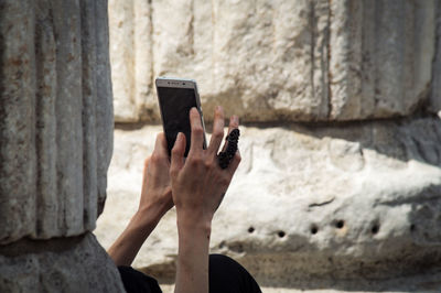 Low section of woman photographing with mobile phone