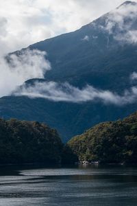 Scenic view of lake by mountains against sky