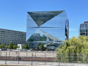 Low angle view of modern buildings against clear blue sky