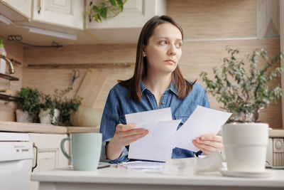 Portrait of young woman reading book at home