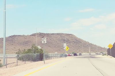 Road by mountain against sky