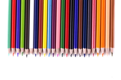 High angle view of multi colored pencils against white background