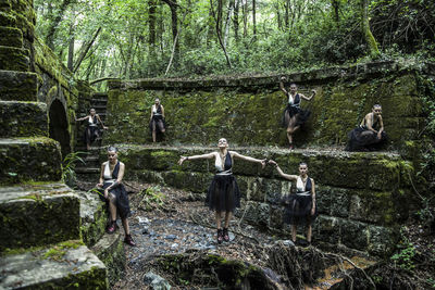 Multiple image of young woman standing on old ruin in forest