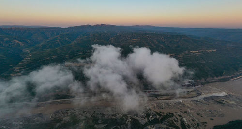 High angle view of smoke emitting from mountain against sky