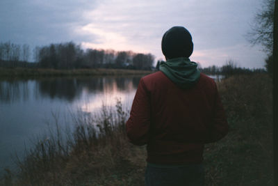 Rear view of man standing on landscape against sky