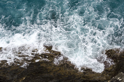 High angle view of waves splashing on rocks