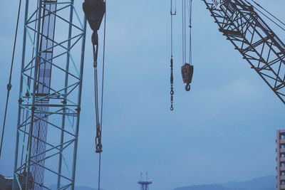 Construction cranes against sky