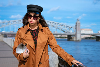 Young woman on the embankment with a newspaper in hand