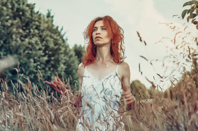 Red woman among dry grass in the garden