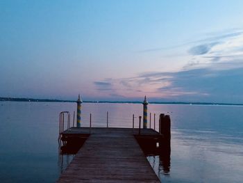 Pier over sea against sky at dusk