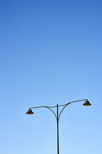 Low angle view of eagle flying against clear blue sky