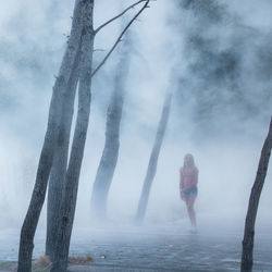 Full length of woman standing in foggy weather