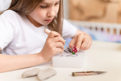 Felt wool craft by handmade needle. kid girl artisan hand makes a creative toy made of sheep hair