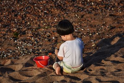 Rear view of girl sitting on land