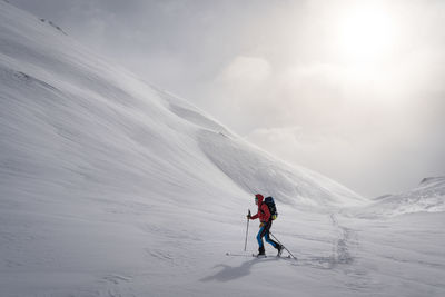 People on snowcapped mountain against sky