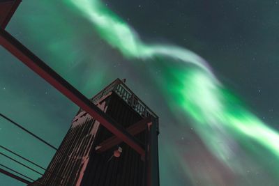 Low angle view of structure against aurora borealis