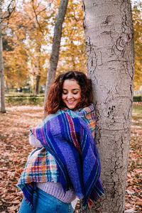 Portrait of a smiling young woman in autumn tree