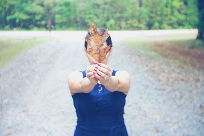 Person holding ice cream cone against blurred background