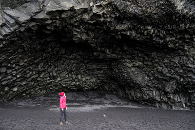 Rear view of woman standing on rock