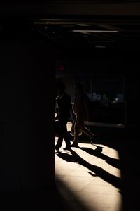 Silhouette people walking in dark room