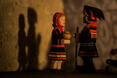 Figurines on table against wall