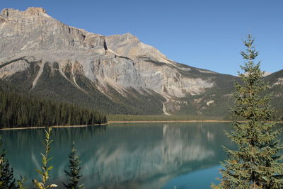 Scenic view of lake and mountains against clear blue sky
