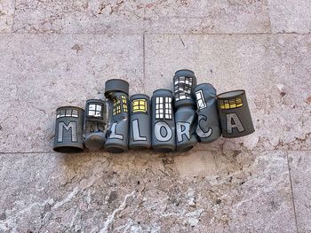 High angle view of text on wall. mallorca text made out of soda cans