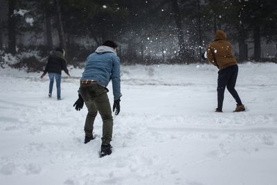 Rear view of people walking on snow covered landscape