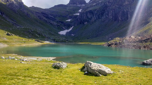 Scenic view of lake by rocks against mountains